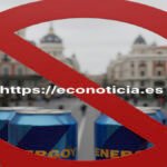 Latas de bebidas energéticas en una calle de España con una señal roja de prohibición y el enlace https://econoticia.es en el centro.