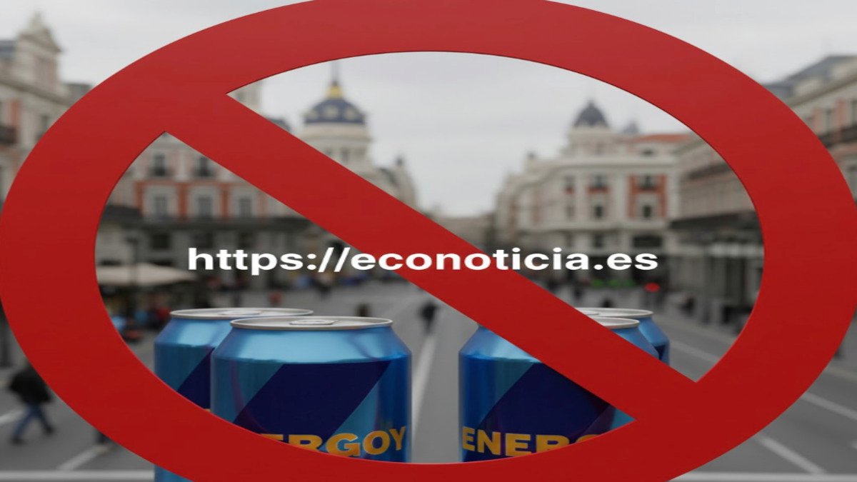 Latas de bebidas energéticas en una calle de España con una señal roja de prohibición y el enlace https://econoticia.es en el centro.
