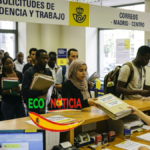Inmigrantes entregando carpetas de solicitud de residencia y trabajo en una oficina de Correos en Madrid para el proceso de regularización.