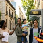 Familias diversas en una calle de España mostrando documentos de residencia legal, con señales de centros de salud y colegios públicos de fondo.