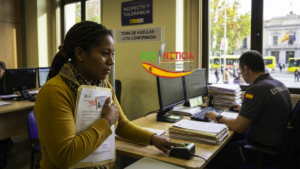 Una mujer inmigrante entregando sus papeles para la toma de huellas en una oficina de extranjería en España.