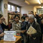 Un grupo de personas esperando en una oficina de servicios sociales en España para tramitar el certificado de vulnerabilidad.