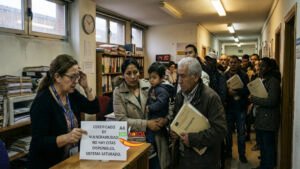 Un grupo de personas esperando en una oficina de servicios sociales en España para tramitar el certificado de vulnerabilidad.