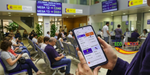 Un teléfono móvil muestra las aplicaciones oficiales para trámites en España dentro de una oficina de atención pública con cita previa - ECO NOTICIA.