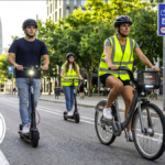 Ciclistas y usuarios de patinetes eléctricos circulan por una vía urbana en España bajo las nuevas normas de circulación impulsadas por la DGT.