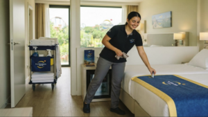 .Empleada de limpieza de PortAventura World preparando una habitación de hotel.