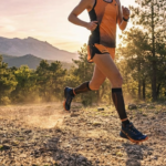 Corredora profesional usando zapatillas de running Bikila en un sendero de montaña al atardecer.