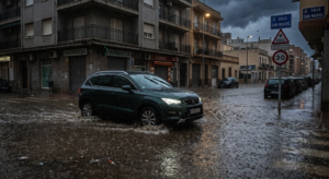 Vehículo circulando por una calle anegada tras lluvias torrenciales