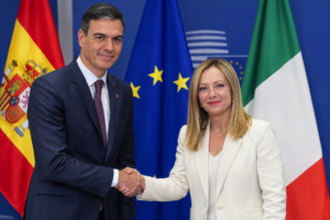 Pedro Sánchez y Giorgia Meloni ante las banderas de España, Italia y la Unión Europea, en referencia a las negociaciones sobre los controles fronterizos.
